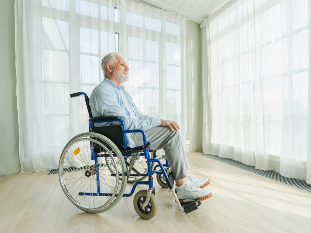 高雄長照補助-一位失能的年長者正在輪椅上望著窗外